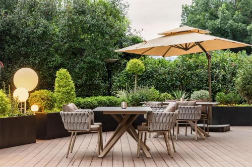 a table and chairs with an umbrella on a patio at Hilton Garden Inn Zhuji East in Shaoxing