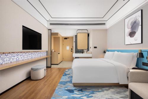 a hotel room with a bed and a tv at Hilton Garden Inn Zhuji East in Shaoxing