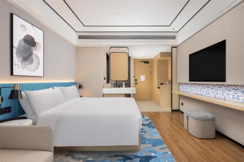 a hotel room with a bed and a tv at Hilton Garden Inn Zhuji East in Shaoxing