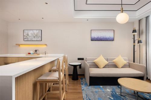 a bar in a hotel room with a counter and chairs at Hilton Garden Inn Zhuji East in Shaoxing