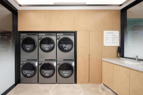 a row of four washing machines in a room at Hilton Garden Inn Zhuji East in Shaoxing