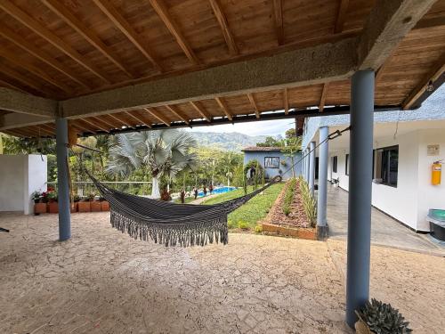 a hammock in a house with a view of a garden at Hotel Selva Cristal in San Carlos