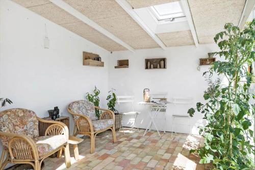 a living room with chairs and potted plants at BL1598-Blokhus-Raevestien-2 in Blokhus