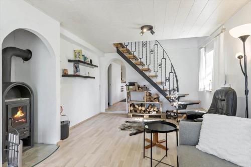 a living room with a fireplace and a staircase at BL1454-Pandrup-Rodhusvej-215 in Pandrup