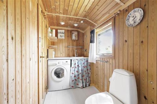 a bathroom with a washing machine and a toilet at 12274-Sjaellands-Odde-Lyngvang-13 in Tjørneholm