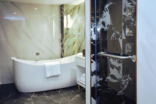 a bathroom with a bath tub and a shower at Pipa Hotel Bangkok Sukhumvit 11 in Bangkok