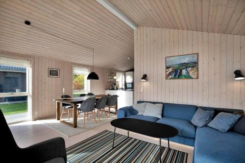 a living room with a blue couch and a table at 11185-Nykobing-Sj-Lynghaekken-8 in Nykøbing Sjælland
