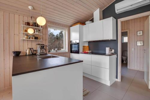 a kitchen with white cabinets and a black counter top at 11185-Nykobing-Sj-Lynghaekken-8 in Nykøbing Sjælland