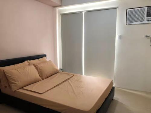 a bed in a room with a window at 1 BR Taytay Condo WIFI Cignal Netflix Pool Patio in Taytay