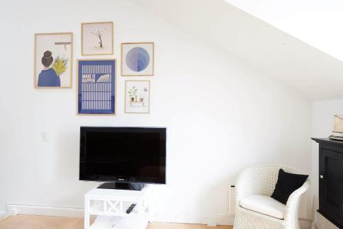 a living room with a tv and a chair at 10057-Nykobing-Sj-Bystedvej-10-Hus-29 in Rørvig
