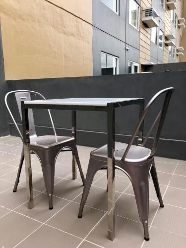 two chairs and a table and a table and chairs at 1 BR Taytay Condo WIFI Cignal Netflix Pool Patio in Taytay