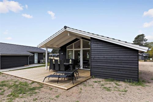a house with a wooden deck with chairs on it at 11197-Nykobing-Sj-Lynghaekken-48 in Nykøbing Sjælland