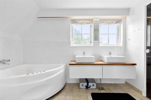 a white bathroom with a tub and two sinks at 10111-Nykobing-Sj-Bystedvej-10-Hus-51 in Rørvig
