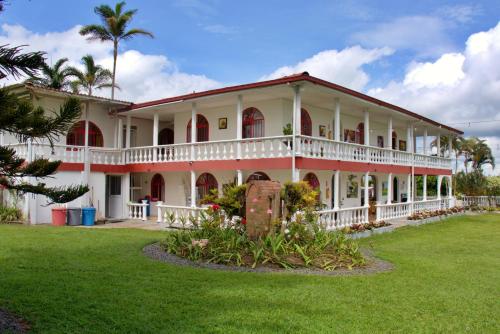 a large white house with a green yard at Hotel Campestre Villa Esmeralda in Pereira