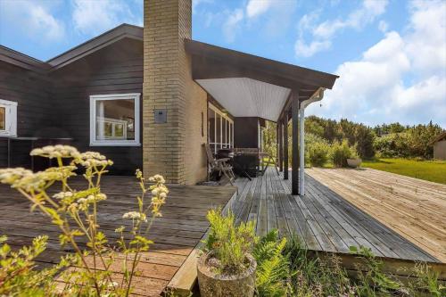 a house with a wooden deck in the yard at 16615-Farevejle-Alfestien-10 in Fårevejle