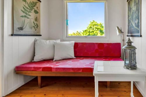 a red couch in a room with a window at 16615-Farevejle-Alfestien-10 in Fårevejle