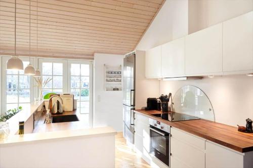 a kitchen with white cabinets and a wooden ceiling at 10014-1-Rorvig-Troldevaenget-5 in Rørvig