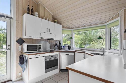 a kitchen with white appliances and a large window at 11174-Nykobing-Sj-Pilehaekken-6 in Nykøbing Sjælland