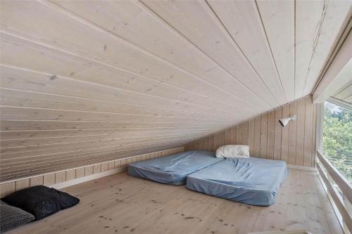 a bed in a room with a wooden ceiling at 11174-Nykobing-Sj-Pilehaekken-6 in Nykøbing Sjælland
