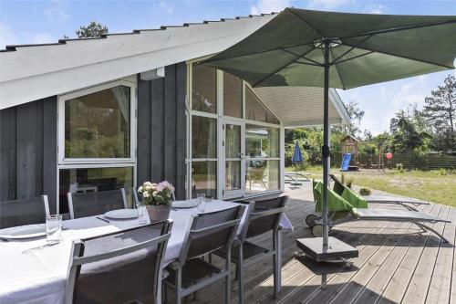 a table with a green umbrella on a deck at 11174-Nykobing-Sj-Pilehaekken-6 in Nykøbing Sjælland