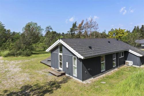 a gray house with a roof on a field at 11174-Nykobing-Sj-Pilehaekken-6 in Nykøbing Sjælland