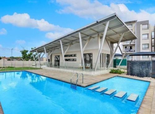 a large swimming pool with a building in the background at 391 at SoHo in Sandton