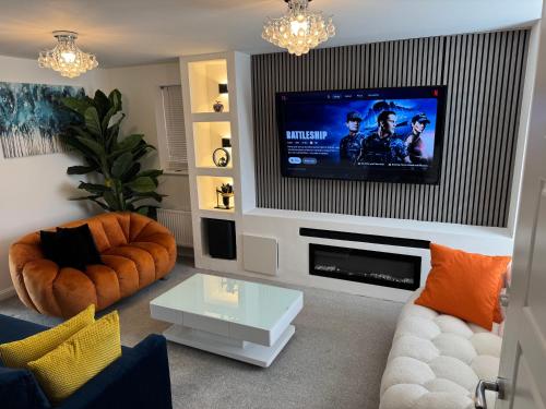 a living room with a flat screen tv on a wall at Alvea Living in Bushbury