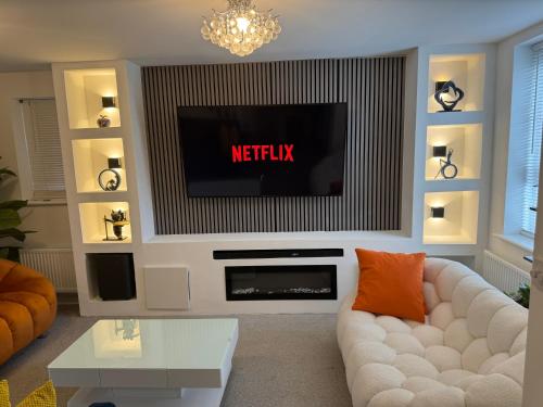 a living room with a tv and a white couch at Alvea Living in Bushbury
