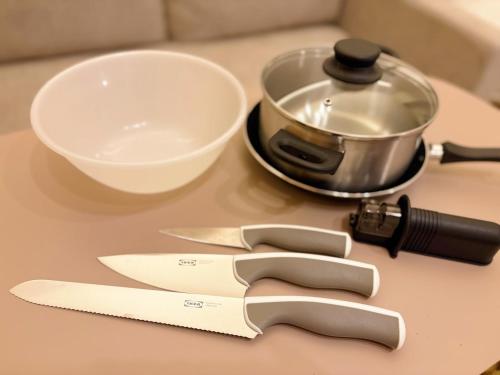 a table with two knives and a bowl and a pot at Calm Flat Hiyoshi in Yokohama