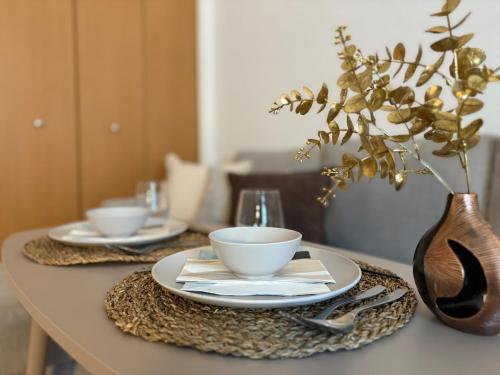 a table with two plates and bowls and a vase at Calm Flat Hiyoshi in Yokohama