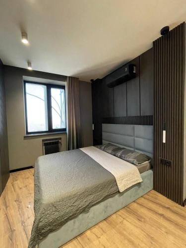 Un dormitorio con una cama grande y una ventana. en Modern apartment, en Dushanbe