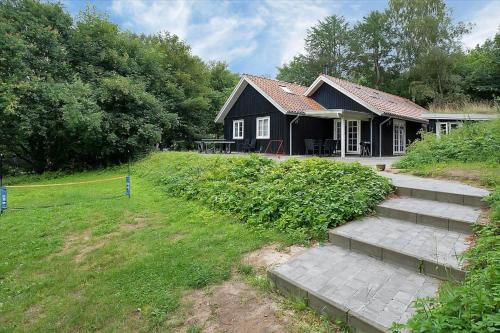 a small black house with stairs in front of it at 16610-Farevejle-Mejsevaenget-26 in Fårevejle