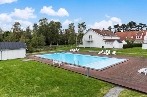 a large swimming pool in a yard with chairs at 10123-Nykobing-Sj-Bystedvej-10-Hus-46 in Rørvig