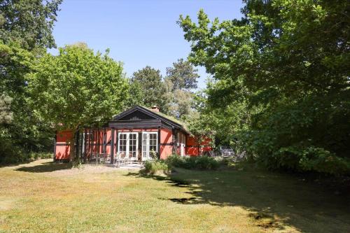 a small red house in a field with trees at 10040-Rorvig-Lyngvaenget-10 in Rørvig