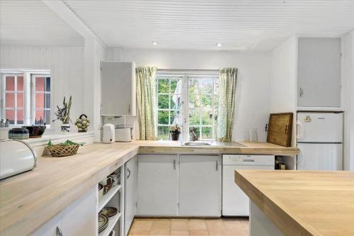 a kitchen with white cabinets and a large window at 10040-Rorvig-Lyngvaenget-10 in Rørvig