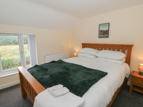 a bedroom with a large bed and a window at Glandwr House in Llandrindod Wells