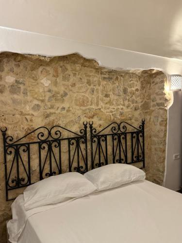 a bed in a room with a stone wall at Casa Dea - Bungalow Aphrodite in Hammamet Sud