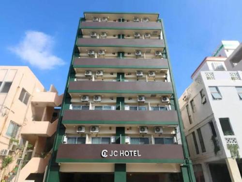 a tall apartment building with a sign on it at JC HOTEL NaHa in Naha