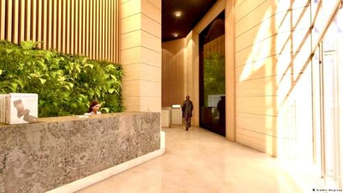 a man walking down a hallway in a building at 2-Bedroom Condotel Stay with Netflix, Kitchen & Washer, Near MRT Boni in Manila