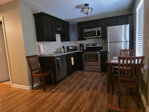 eine Küche mit schwarzen Schränken und Edelstahlgeräten in der Unterkunft Golden Pines Villa on Choice Ave Steps to Downtown in Dahlonega