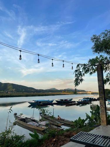 a group of boats on a river with lights at Horizon Homestay in Phong Nha