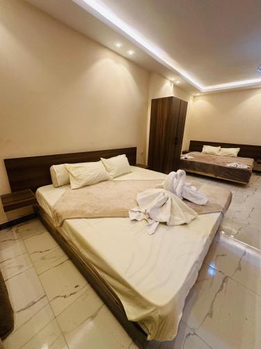 a bedroom with a large bed with towels on it at Pyramids sun set view in Cairo