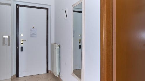a hallway with a door and a mirror at App 22 - Appartamento ad Angolo con Balcone in Monza