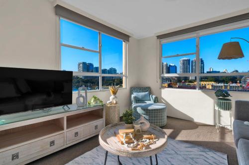 a living room with a large flat screen tv at Harbourviewnest in Sydney
