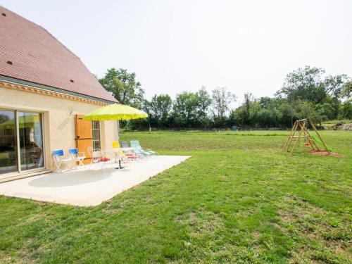 a yard with a playground with a yellow umbrella and a swing at Maison familiale avec terrasse, clim et jeux enfants en Périgord - FR-1-616-334 in Sainte-Orse