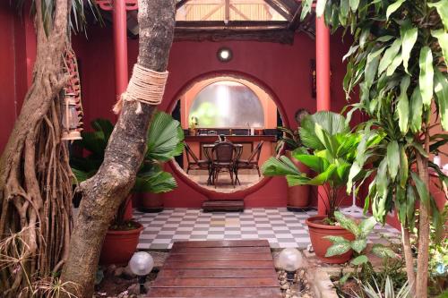 ボラカイにあるRabbit Hole Villaのテーブルと植物が置かれた赤い部屋