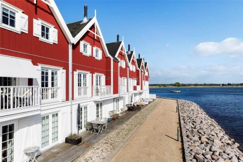 a row of red and white buildings next to the water at 11207-Nykobing-Sj-Havnevej-65-1-th in Nykøbing Sjælland