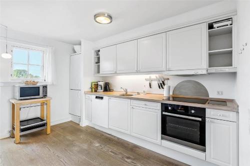 a kitchen with white cabinets and a counter top at 11207-Nykobing-Sj-Havnevej-65-1-th in Nykøbing Sjælland