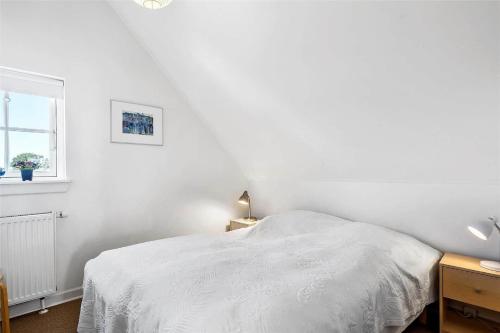 a white bedroom with a bed and a window at 11207-Nykobing-Sj-Havnevej-65-1-th in Nykøbing Sjælland