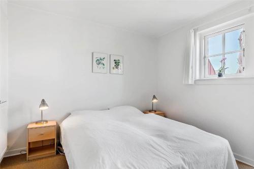 a white bedroom with a bed and a window at 11207-Nykobing-Sj-Havnevej-65-1-th in Nykøbing Sjælland